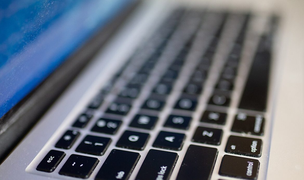 Pracownik biurowy korzystający z laptopa przy biurku